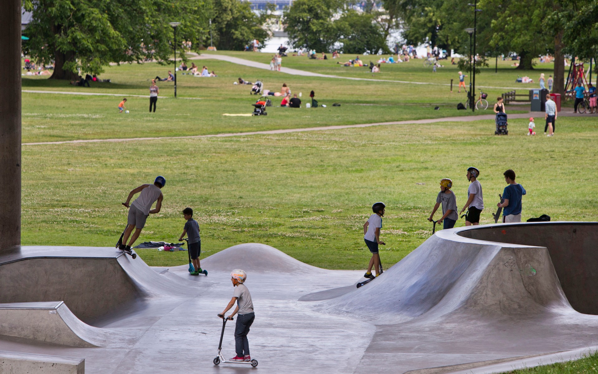 Barn och ungdomar åker skateboard och kickbike i Rålambshovsparken